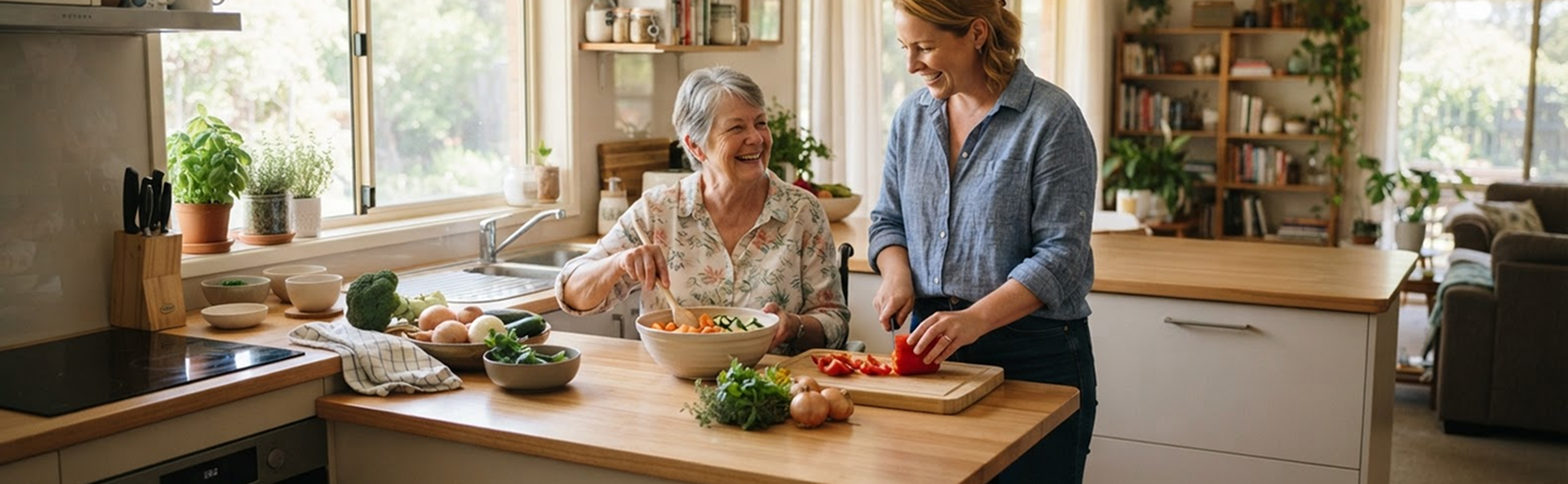 Support worker and participant preparing vegetables together in a bright kitchen